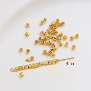 Vista macro de cuentas redondas texturizadas bañadas en oro de 3mm para joyería