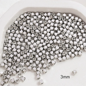 Macro detail of 3mm silver faceted cube metal spacer beads for DIY jewelry making