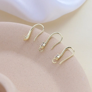 Primer plano de ganchos para pendientes chapados en oro 18K con circonitas para joyería DIY