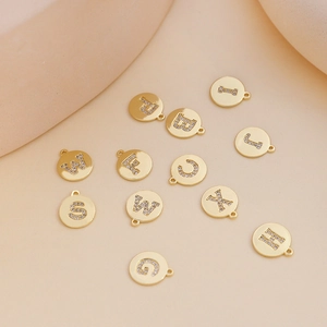 Macro view of gold plated alphabet pendants with cubic zirconia for DIY jewelry making