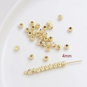 Vue macro de perles dorées de 4mm avec rayures verticales pour bijoux DIY