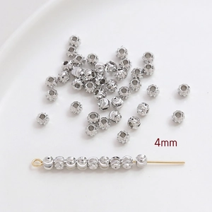 Vue détaillée de perles en cuivre argenté 4mm texturées pour création de bijoux