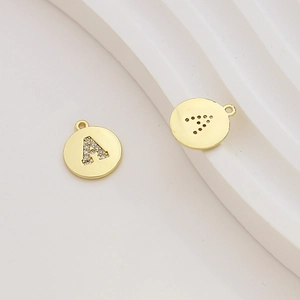 Macro detail of gold-plated letter A pendant with cubic zirconia inlay and back holes