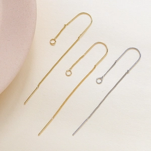 Detailed view of U-shaped gold and silver earring wire hooks with chains for DIY jewelry