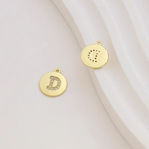 Detail of 18k gold plated letter D pendant with sparkling cubic zirconia inlay