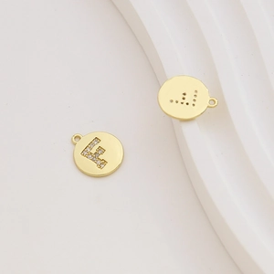 Detailed macro view of 18k gold plated letter F charm with micro-set cubic zirconia stones