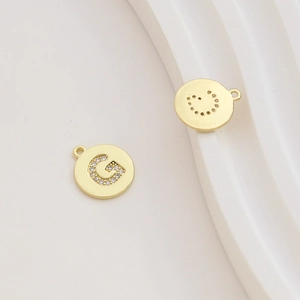 Detail of gold-plated letter G charm with pavé cubic zirconia for DIY jewelry