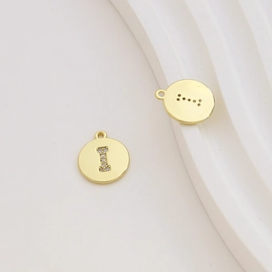 Macro shot of gold plated letter I pendant with zircon inlay and top jump ring detail