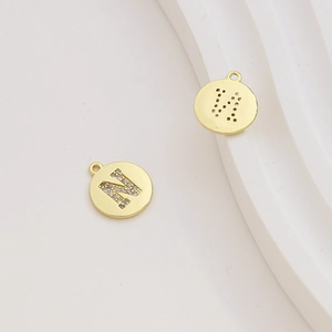 Macro detail of gold-plated letter N pendant with pavé cubic zirconia and honeycomb back