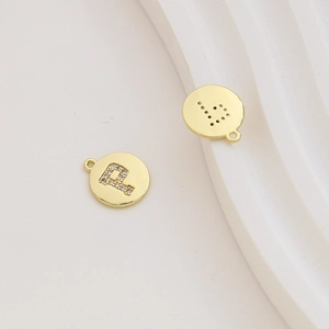 Macro detail of gold-plated letter P pendant with zircon inlay for DIY jewelry