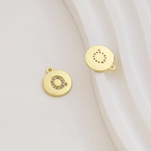 Detailed macro of gold-plated letter Q pendant with zircon stones for DIY jewelry making