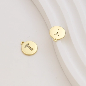 Macro detail of 18k gold plated letter T charm with cubic zirconia pavé setting