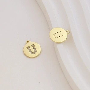 Macro detail of 18K gold plated letter U charm with cubic zirconia and hollow back design
