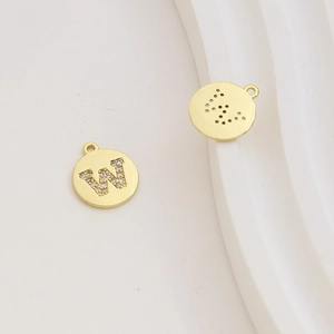 Macro detail of gold-plated letter W charm with cubic zirconia for DIY jewelry making