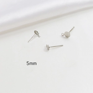 Macro detail of 5mm flat round earring posts with loops for DIY jewelry making