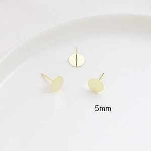 Macro detail of 5mm gold plated flat stud earring bases for DIY jewelry making