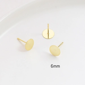 Detailed macro view of 6mm gold-plated S925 silver flat pad ear studs for jewelry DIY