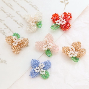 Detailed close-up of handmade beaded floral charms for DIY hair accessories and jewelry