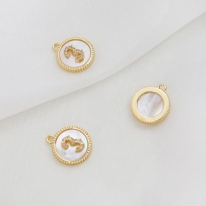 Λεπτομέρεια macro από επίχρυσα charms 18k με φίλντισι και νούμερο 3 με ζιργκόν