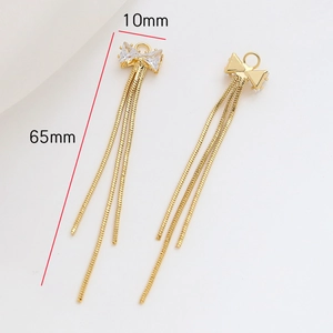 Détail du pendentif nœud avec zircon et pompons dorés montrant dimensions 10mm et 65mm