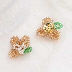 Detailed close-up of handmade beaded crystal flowers with golden metal base for DIY jewelry
