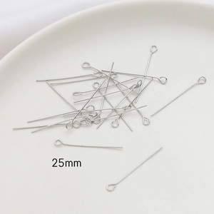 Close-up of 25mm silver eye pins for DIY jewelry making displayed on a white plate