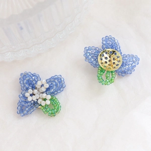 Handmade beaded flower earrings with blue crystal petals and gold metal base detail