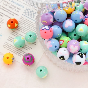 Detailed macro view of colorful acrylic beads with painted heart and star patterns for DIY jewelry