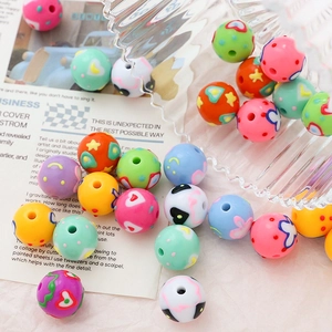 Macro shot of colorful acrylic beads with hand-painted patterns for DIY jewelry making