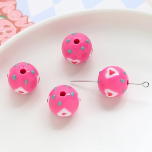 Macro detail of pink acrylic heart beads with polka dots for DIY jewelry making