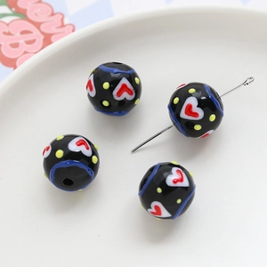 Macro view of acrylic beads with heart patterns and thread holes for DIY jewelry