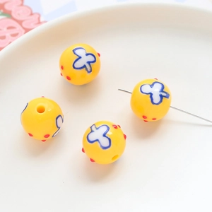 Macro view of yellow acrylic beads with floral patterns for DIY jewelry making