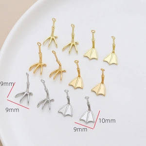 Vista macro di ciondoli a forma di zampa d'anatra e artiglio placcati in oro 18k per fai da te