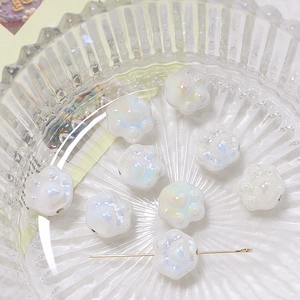 Macro view of iridescent white ceramic cat paw beads for DIY jewelry and necklaces