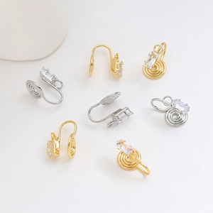 Dettaglio macro di clip per orecchie a spirale placcate oro 18k con zirconi rettangolari