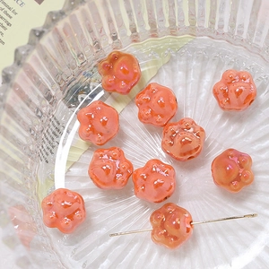 Macro shot of colorful cat paw ceramic beads for DIY jewelry making in a glass bowl