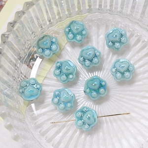 Macro shot of light blue ceramic cat paw beads for DIY jewelry making and bracelets