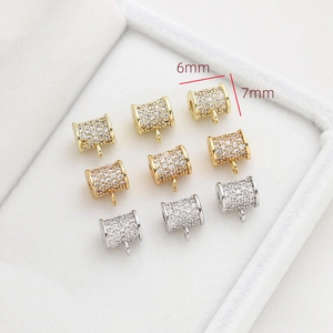 Detailed view of 6mm zircon-encrusted gold and silver cylindrical jewelry spacers