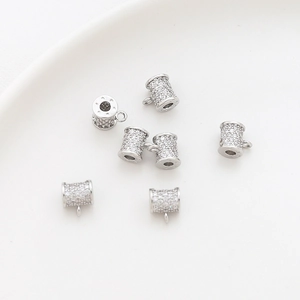 Macro view of micro-pave zircon charms in bright silver for DIY jewelry making