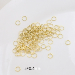 Detalle de anillas abiertas chapadas en oro de 5x0.4mm para bisutería artesanal DIY