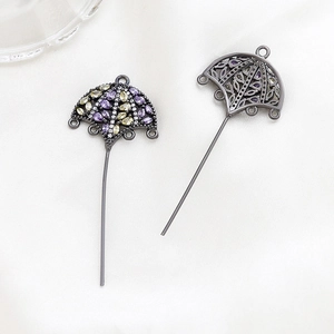 Detailed macro view of zircon-studded crown umbrella pendant with metallic plating