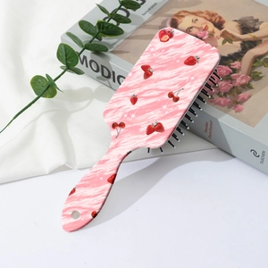 Détail de la brosse à cheveux aux fraises sur des livres de décoration raffinés