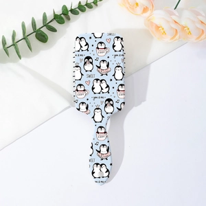 Détail de la brosse à coussin d'air pingouin sur tissu blanc avec décor floral