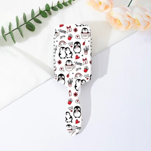 Détail de la brosse blanche avec motifs de pingouins mignons et coussin d'air massant