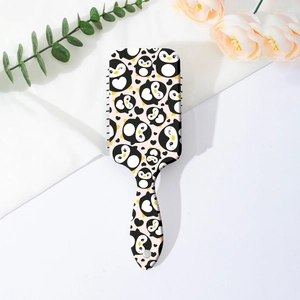 Vue détaillée d'une brosse à cheveux rectangulaire avec motifs pingouins mignons