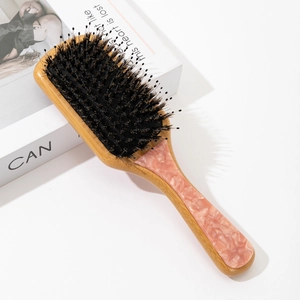 Macro view of bamboo hairbrush with pink marble pattern and mixed boar bristles