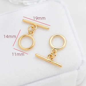 Détail macro de fermoirs à bascule OT dorés pour bijoux sur support en velours blanc