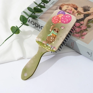 Detailed view of olive green hairbrush featuring a cute sloth illustration and floral pattern