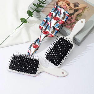 Colorful feather print hair cushion brush with massage bristles on a white aesthetic background