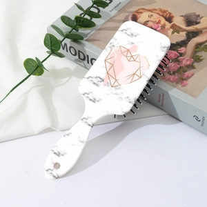 Chic air cushion brush with marble pattern and heart motif on a stylish desk setup